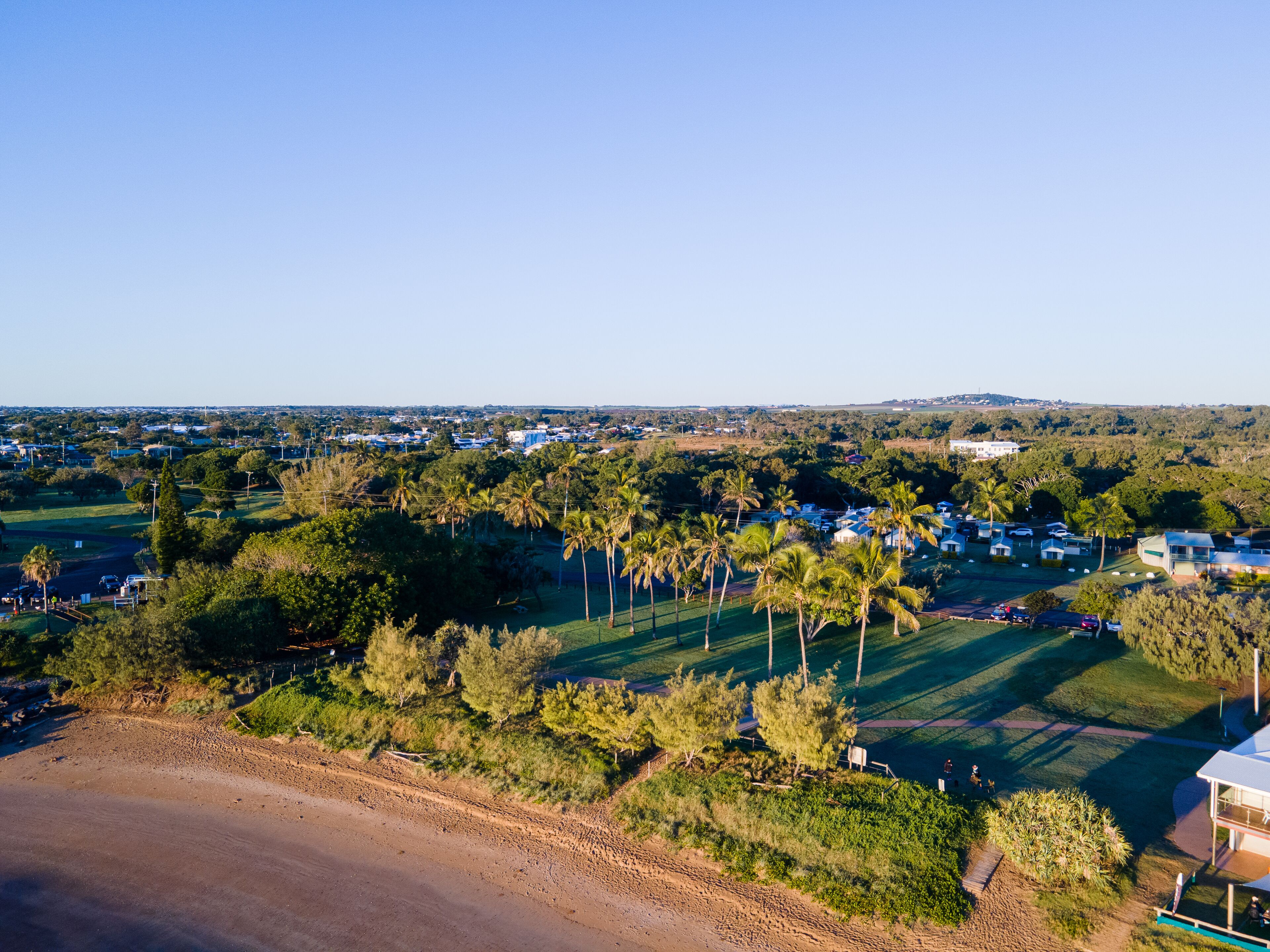 Zona residencial con casas, palmeras y cielo despejado.
