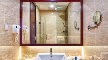A modern bathroom with a large mirror, a sink, a shower, and a hairdryer.