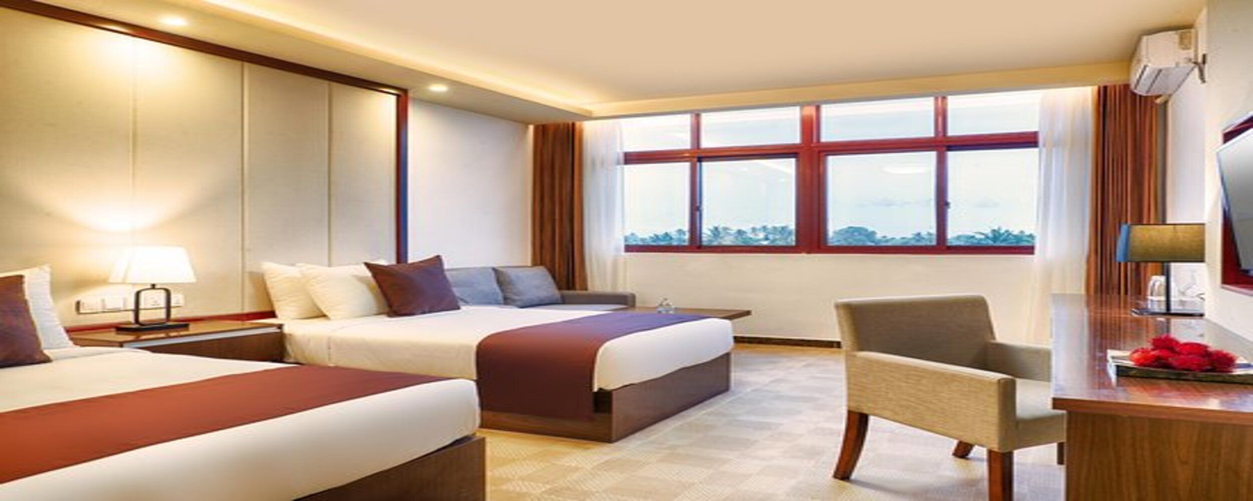 A hotel room with two beds, a desk, a chair, and a large window with a view.