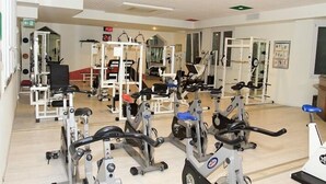 Ein Fitnessstudio mit verschiedenen Trainingsgeräten, darunter Laufbänder und Kraftgeräte.