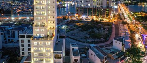 A multi-story hotel with a prominent 'Gem Hotel' sign, surrounded by urban buildings and a waterfront.
