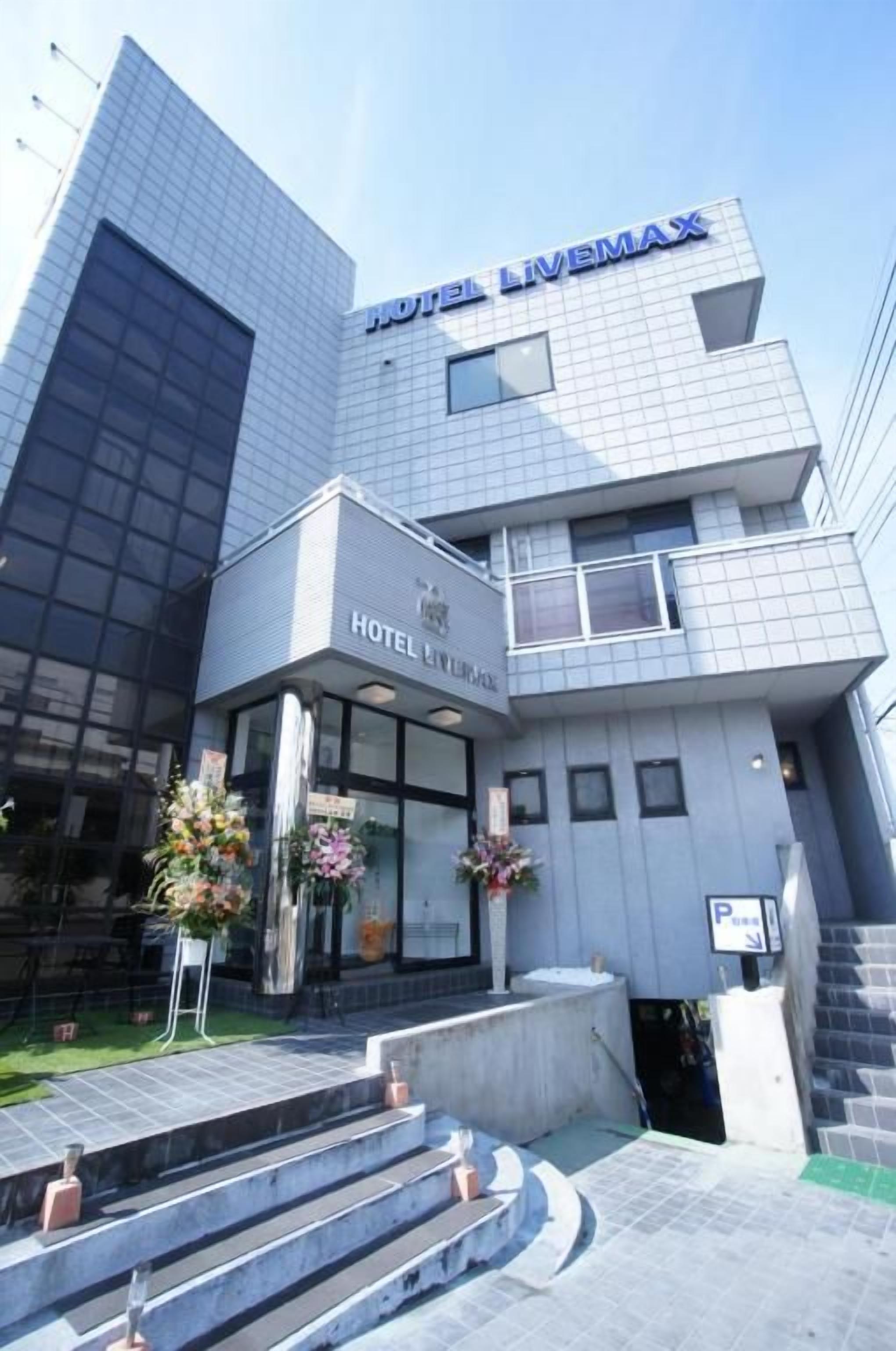 A modern hotel building with a prominent sign reading 'HOTEL LIVEMAX'.