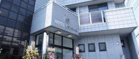 A modern hotel building with a prominent sign reading 'HOTEL LIVEMAX'.