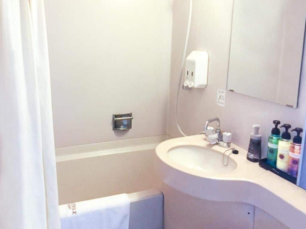 A bathroom with a sink, mirror, and toiletries.