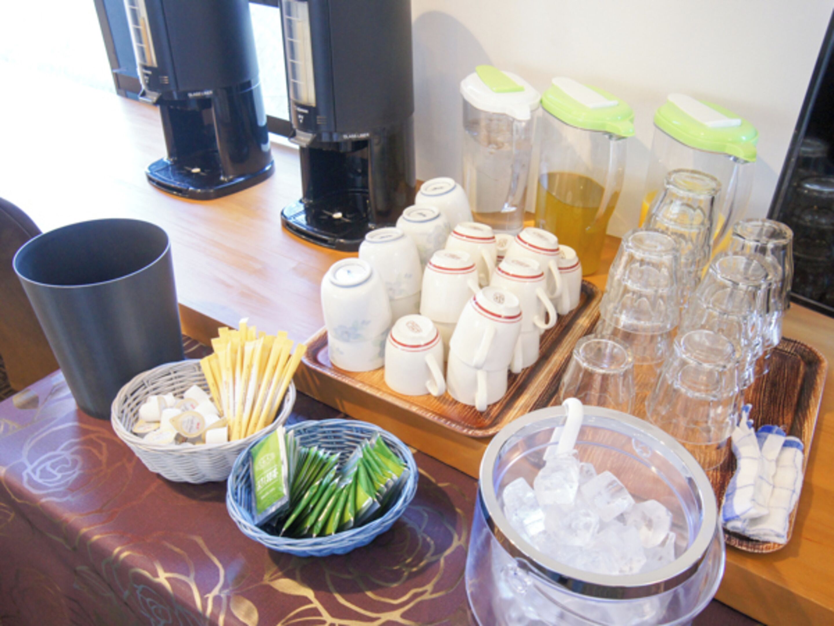 A buffet setup with various food items and drink dispensers.