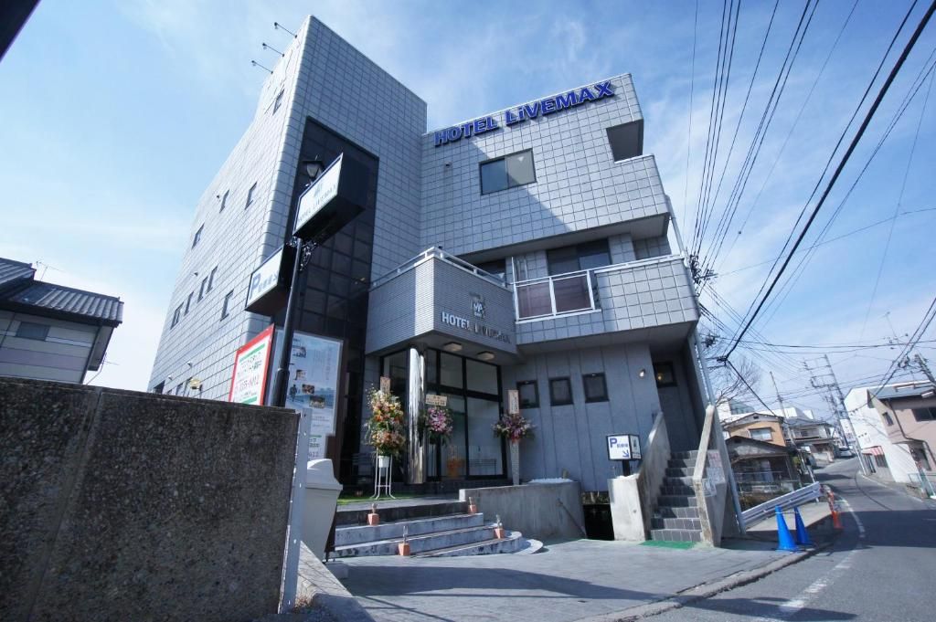 A modern hotel building with a prominent sign reading 'HOTEL LIVEMAX'.