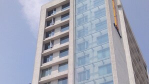 A tall building with a modern design, featuring a glass facade and multiple floors.