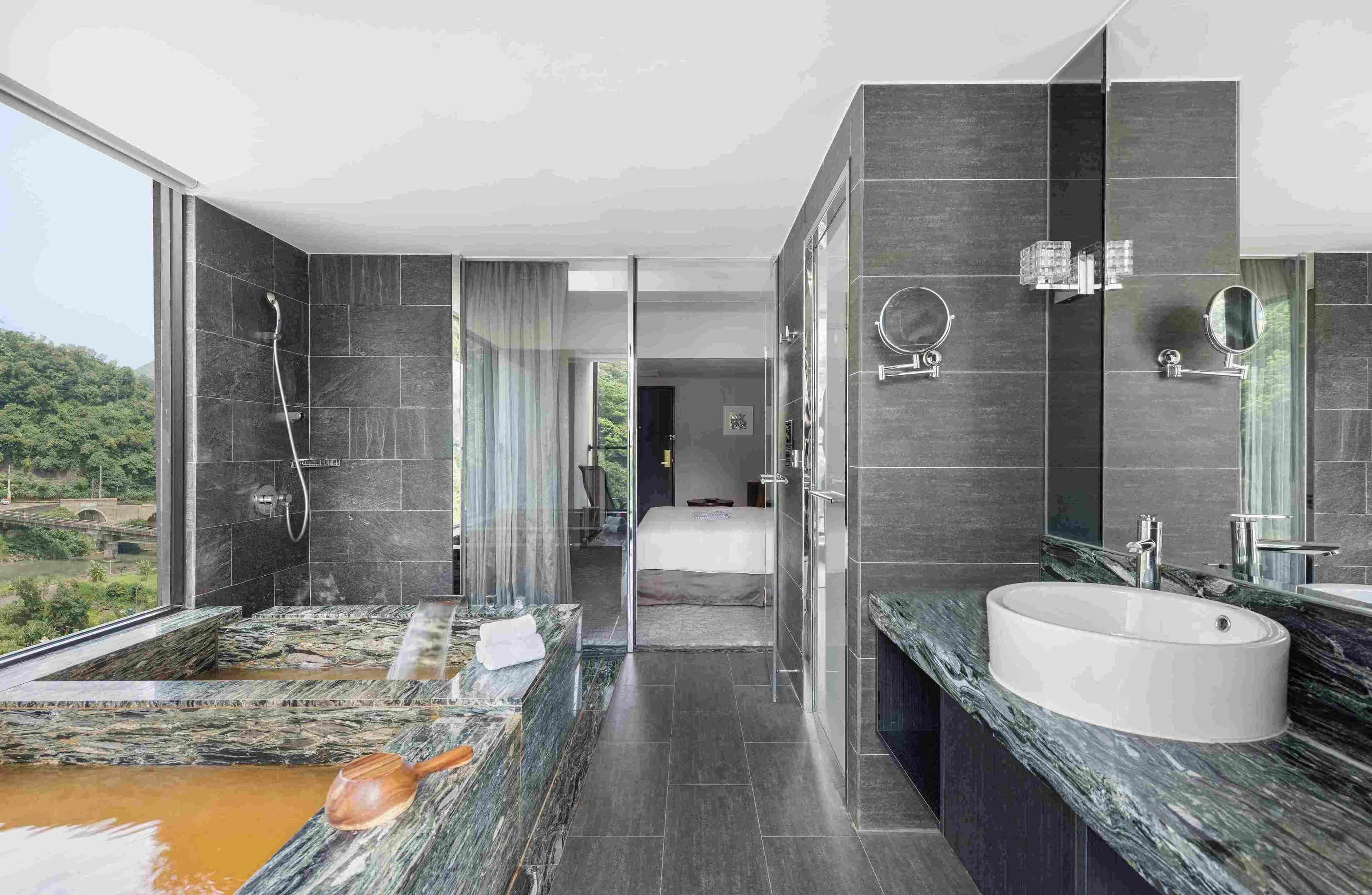 A modern bathroom with a large bathtub, a separate shower area, and a vanity with a sink and mirror.