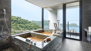 Un baño moderno con una bañera grande, ducha y vistas a un paisaje montañoso.