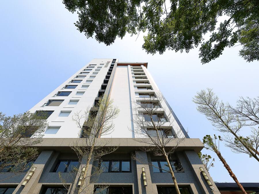 A tall building with multiple floors, large windows, and a modern architectural design.
