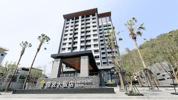Un hotel moderno con una entrada destacada y un letrero al frente.