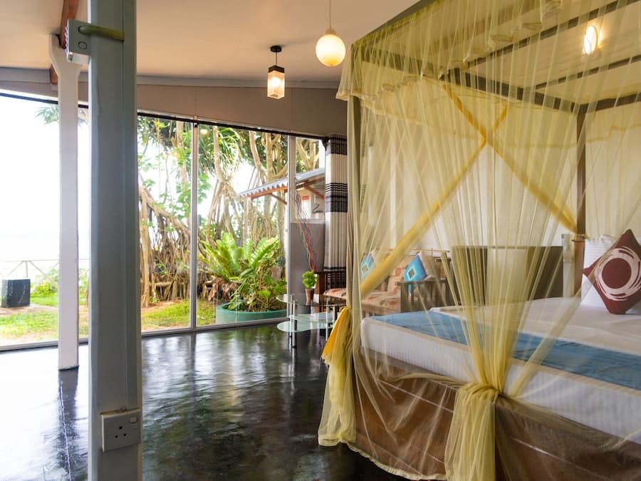 A bedroom with a bed, a window, and a view of the outdoors.