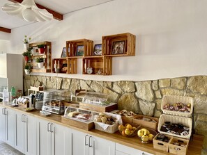 En morgenmadsbuffet med forskellige spiser, træhylder og en baggrunds murstensvæg.