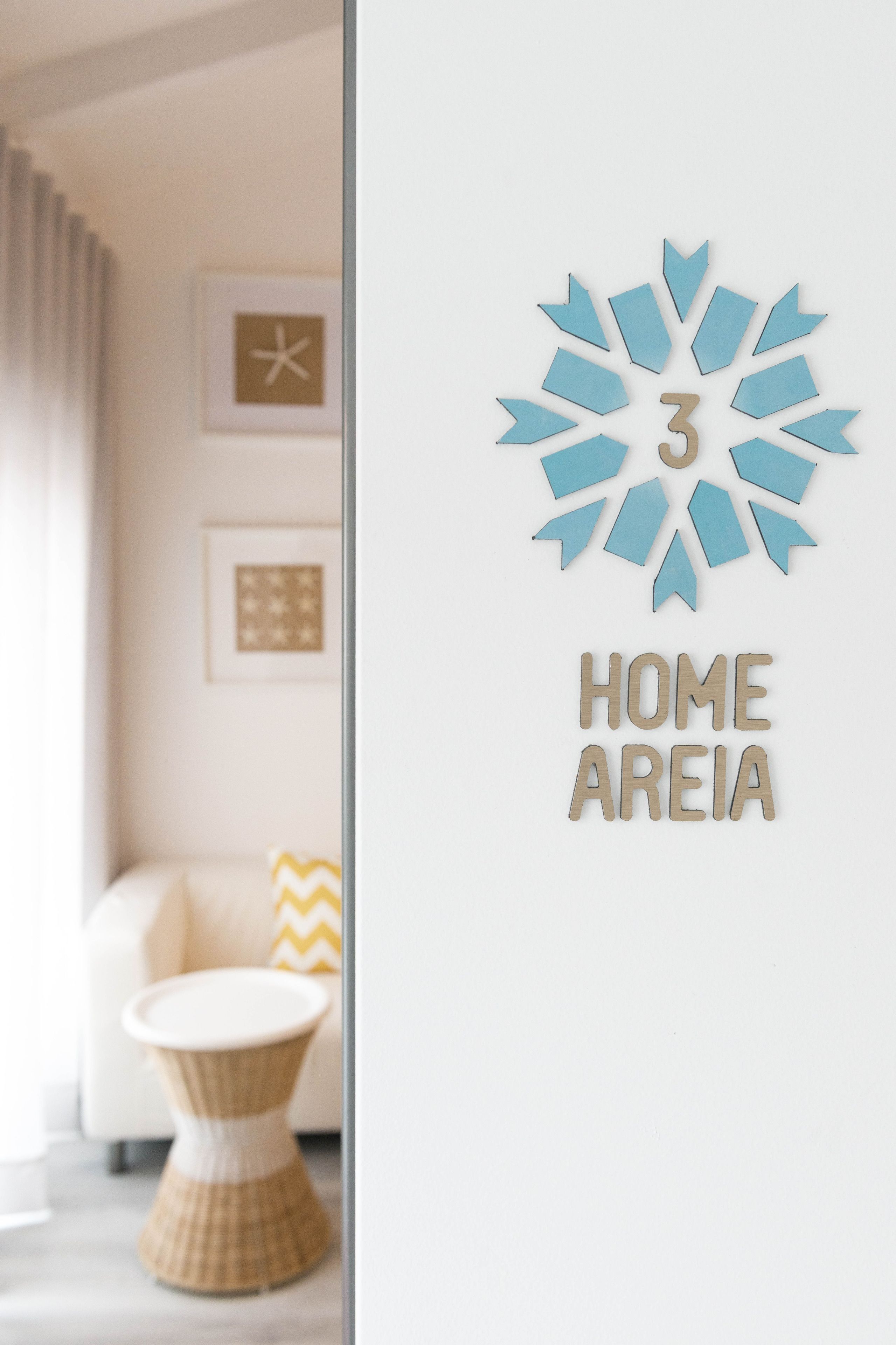 Un mur orné d’un chiffre « 3 » décoratif et de l’inscription « HOME AREIA ».
