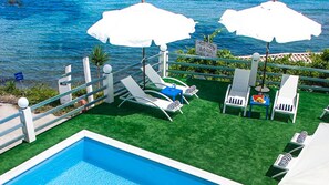 Piscine extérieure, parasols de plage, chaises longues