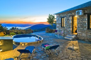 A stone building with a pool, outdoor seating, and a view of the mountains. - Pelion Goddess Villas (Volos)