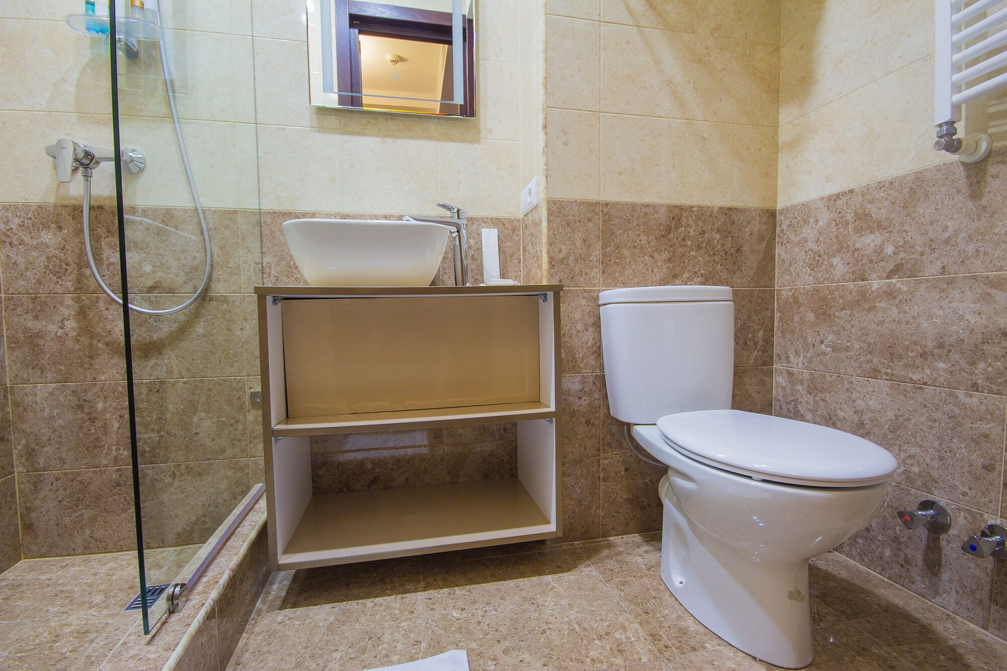 A bathroom with a toilet, a sink, and a shower area.