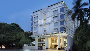 A multi-story hotel with ornate architectural details, large windows, and a well-lit entrance. - La Marvella, Bengaluru (Bengaluru)