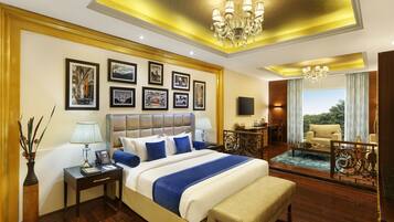 A spacious bedroom with a large bed, bedside tables, a desk, and a balcony with a view.