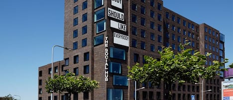 A multi-story building with a sign reading "EVERY BODY SHOULD LIKE EVERYBODY THE SOCIAL HUB."