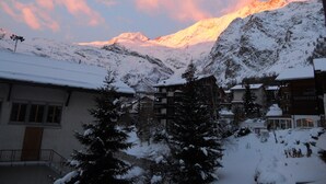 A snow-covered mountain with a hotel named "Hotel Schwiz" in the foreground. - Chalet Alpenruh (Saas-Fee)