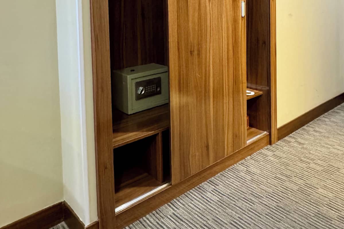 A wooden closet with a microwave inside.