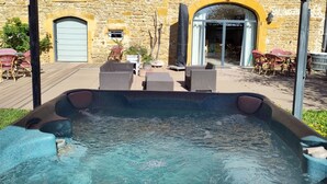 A covered outdoor seating area with wicker furniture and a hot tub. - Le Clos du Cher en Beaujolais (Saint-Germain-Nuelles)