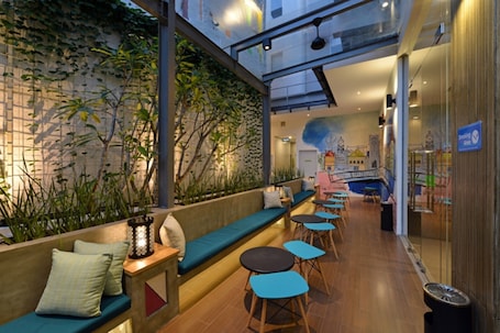 An indoor seating area with a low wall, wooden tables, and benches.