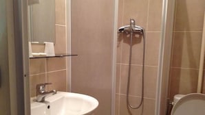 A bathroom with a sink, mirror, shower, and toilet. - Hôtel Nice Savoie (Nice)