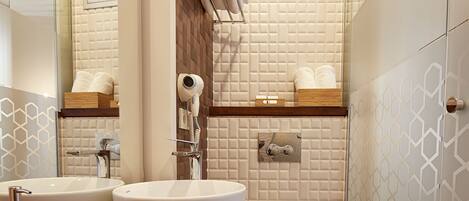 Une salle de bain moderne avec deux lavabos, des toilettes, une douche et un porte-serviettes.