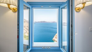 Habitació amb una finestra gran que ofereix vista al mar i als penya-segats.
