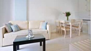 Ein modernes Wohnzimmer mit einer Couch, einem Couchtisch und einem Essbereich mit Stühlen und einem Tisch.