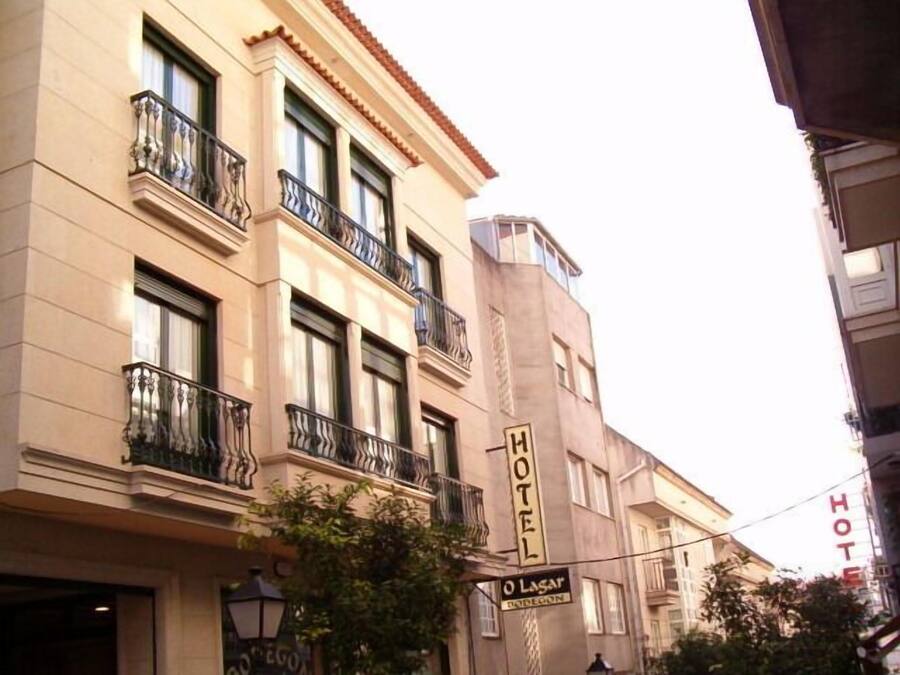 Un hotel con fachada clásica, varios balcones y un llamativo letrero que dice 'HOTEL'.