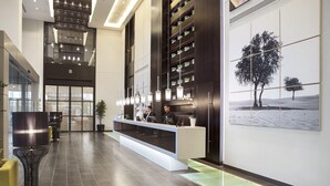 A modern hotel lobby with a reception desk, seating area, and a large wall art piece. - Centro Shaheen Jeddah by Rotana (Jeddah)
