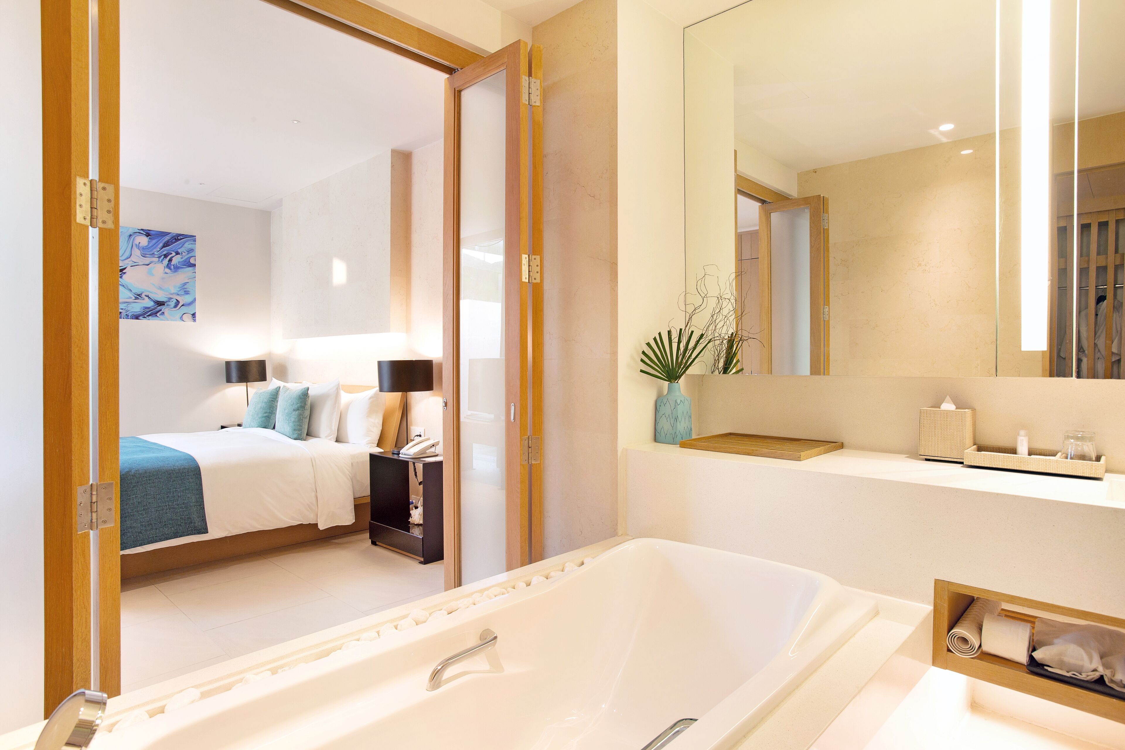 A modern bathroom with a large bathtub, a mirror, and a vanity with a sink.