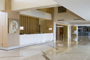 En moderne hotellobby med en reception, et stort 'R'-skilt og indgang til et kasino.