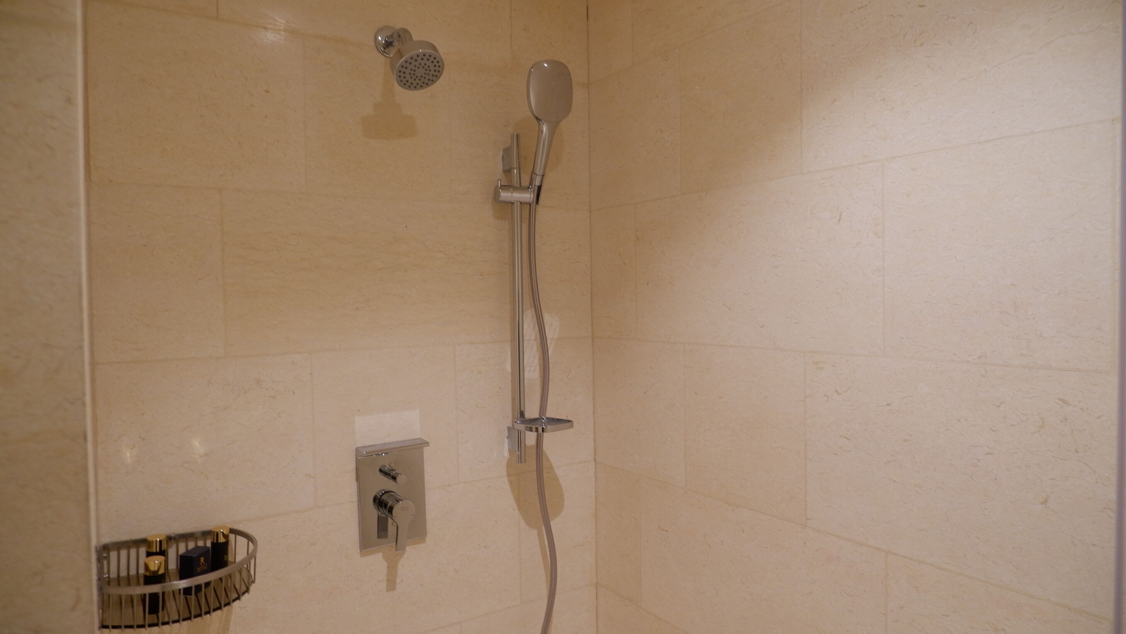 Un baño con ducha, inodoro y secador de manos.