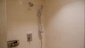 Un baño con ducha, inodoro y secador de manos.