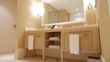 A modern bathroom with a large mirror, wooden cabinetry, and two towel racks.