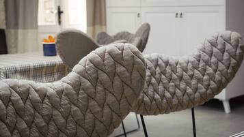 Una habitación con una colcha a cuadros, un armario blanco y una ventana con cortinas.