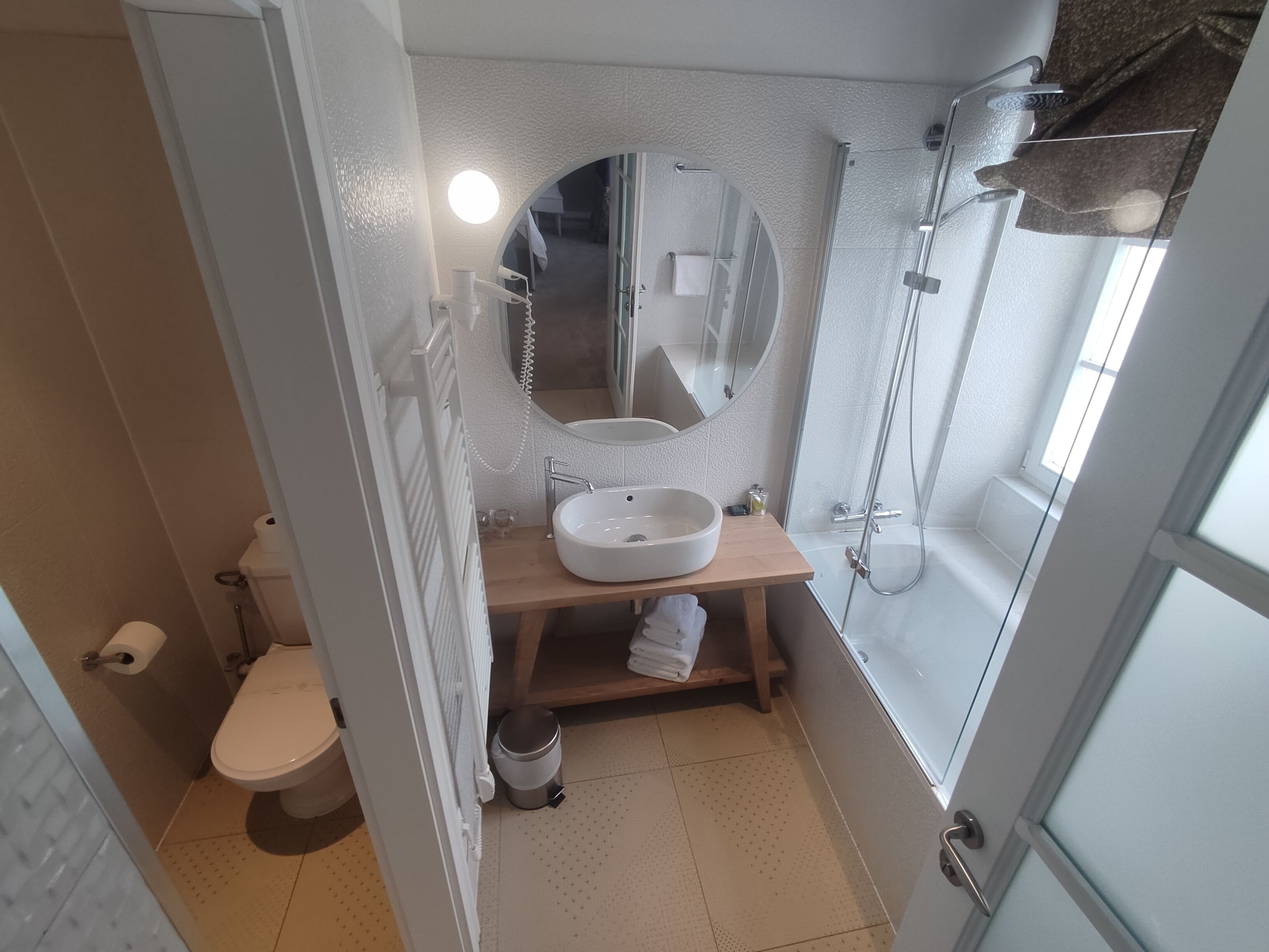 A compact bathroom with a toilet, sink, and shower.