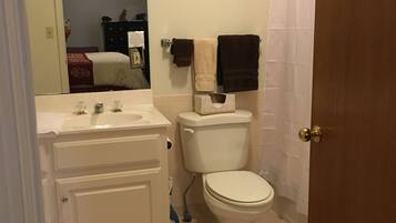 Een badkamer met toilet, wastafel en spiegel.