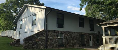 A two-story house with a stone foundation and a white exterior.
