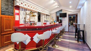 A bar area with a red counter, white bar stools, and a variety of bottles and glasses. - Victoria (Linares)
