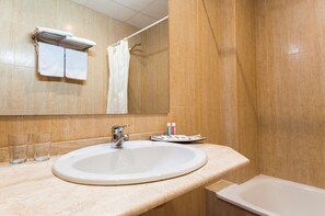 Un baño con lavamanos, espejo, toallero y cortina de ducha.