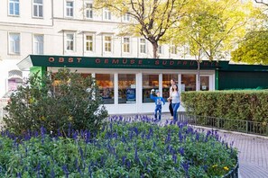 A storefront with a sign reading "OBST GEMUSE-SÜDFRUHTE".