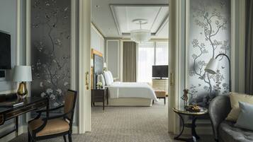 Une chambre d’hôtel comprenant un lit, un bureau avec une lampe, une chaise, un canapé et un téléviseur.