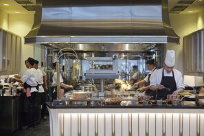 A professional kitchen with stainless steel appliances, chefs in uniform, and a well-organized workspace. - Four Seasons Hotel Jakarta (Jakarta)