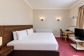 A hotel room with a large bed, a desk with a chair, a television, and two wall-mounted lights. - Nant Ddu Lodge Hotel & Spa by Belvilla (Merthyr Tydfil)