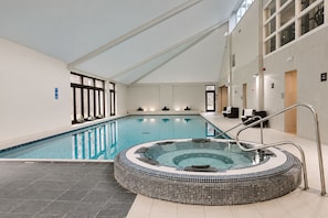 An indoor swimming pool with a hot tub, clear water, and a tiled floor. - Nant Ddu Lodge Hotel & Spa by Belvilla (Merthyr Tydfil)